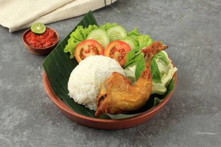 Foto de Ayam Goreng con Nasi y Sambal, pollo frito estilo indonesio servido con arroz al vapor y pasta picante - Imagen libre de derechos