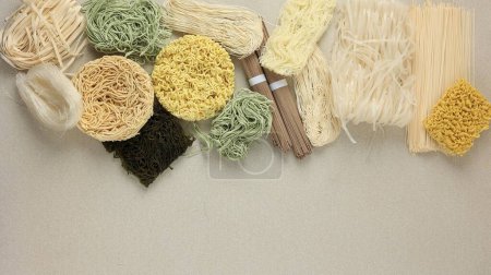 Photo for Various Type Raw Asian Noodle, Soba, Ramen, Ramyeon, Misua, Char Kway Teow, Vegetable Egg Noodle, Somen. Top View on Cream Table. Copy Space for Text - Royalty Free Image