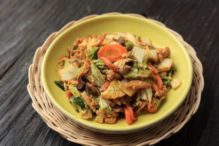Capcay Goreng in Großaufnahme auf Holztisch. Chinesisches Essen Indonesisches Bratengemüse mit Huhn und Meeresfrüchten