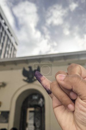 Petit doigt féminin marqué à l'encre électorale. Pemilu Indonésie avec Jari Bertinta