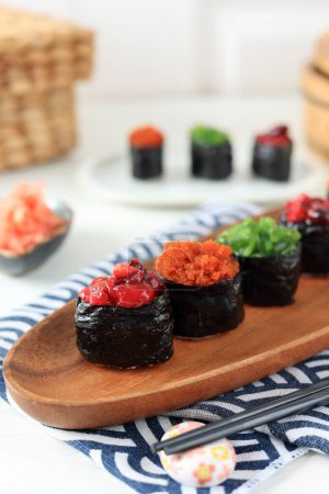 Homemade Sushi Gunkan Maki with Various Topping on Wooden Plate 