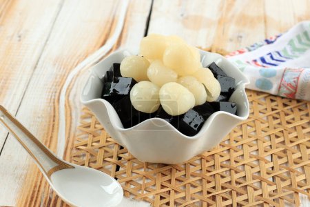 Schwarzes Grasgelee Mesona chinensis mit Fruit Longan Topping. Gemüsegelee schwarz serbed mit Zuckersirup. 