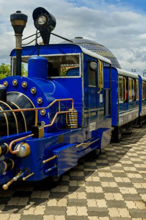 Foto de Un tren de juguete eléctrico de color azul que lleva a la gente a dar un paseo y ver la vista en Eco Park, Calcuta. Enfoque selectivo. - Imagen libre de derechos