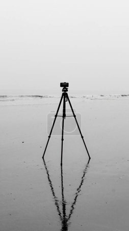 Foto de Una imagen monocromática de un trípode erguido en una playa - Imagen libre de derechos