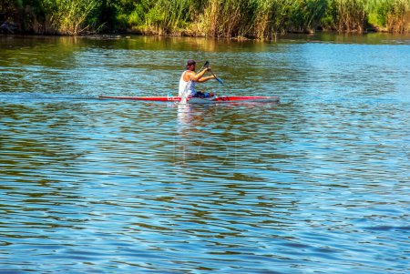 Photo for Dnipro, Ukraine - 06.20.2023: Technique of rowing of a single athlete on a kayak. Paddle splash motion. - Royalty Free Image