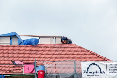 Photo for Nitra, Slovakia - 05.15.2023: Handymen repair chimneys on the roof of a house. - Royalty Free Image