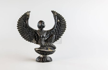 Photo for Close-up of a miniature figurine of the ancient winged Egyptian god Isis. - Royalty Free Image