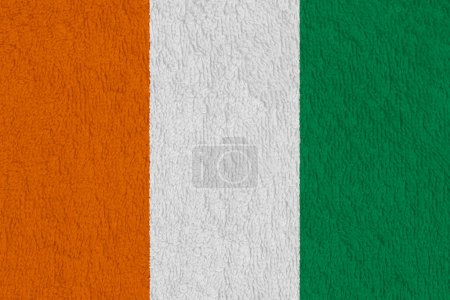 Flag of Republic of Cote d'Ivoire on a textured background. Concept collage.