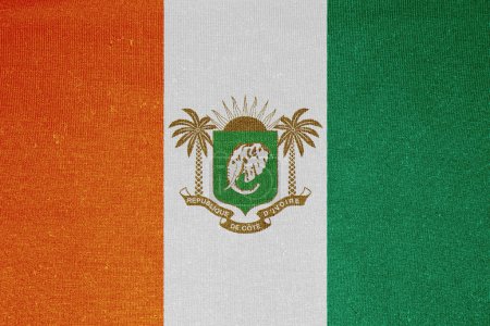 Flag and coat of arms of Republic of Cote d'Ivoire on a textured background. Concept collage.