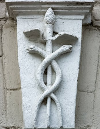 Caduceus as a symbol of medicine. A simplified image of the Caduceus on the facade of a building.