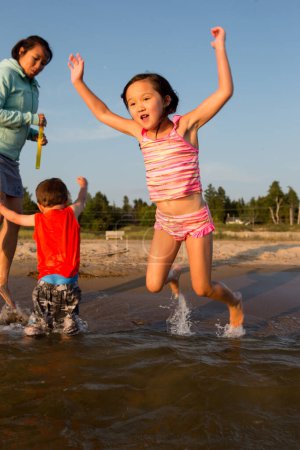Téléchargez les photos : Happy Mixte Race Famille Jouer et s'amuser sur la plage - en image libre de droit