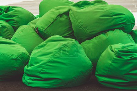 Foto de Sillas de bolsa de frijol. una pila de bolsas verdes sillas Concepto de mobiliario contemporáneo al aire libre cómodo. cómodas almohadas suaves para sentarse y tumbarse - Imagen libre de derechos