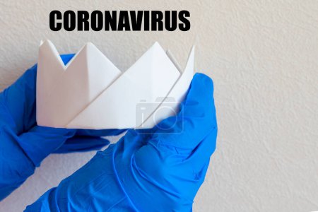 Foto de Corona blanca y guantes médicos, coronavirus inscripción. El concepto de la lucha contra el coronavirus. Concepto pandemia, gripe. - Imagen libre de derechos