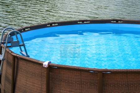 La piscina marco con agua azul al aire libre. Cerca del río la piscina Frame. El área azul en la cual el lavabo inflable. Agua en el embalse sobre el fondo del agua en el río. marco piscina