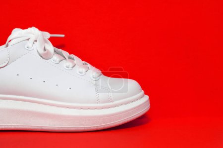 white sneaker,  colored  surface. sport shoes, side view. Copy space