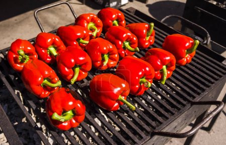 Photo for Har grilled red  bell peppers, cooked on the grill, street food closeup.  grilled vegetables on the town picnic. red beautiful pepper before preparation on a grill. - Royalty Free Image