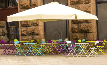 Téléchargez les photos : Café cafétéria vide. tables et tabourets colorés dans la rue.Tables en fer de couleur sous un dôme. vide, personne - en image libre de droit