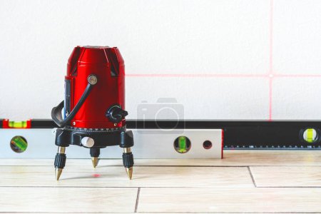 Laser level and Bubble levels, lines on the wall. measuring  with red laser level.Measurement accuracy concept, modern measurement devices