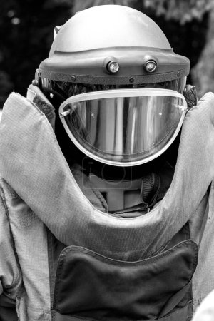 Armor costume consisting of a steel helmet. The concept of demining of city objects. Prevention of threat of explosions and life of people. Black and white photo