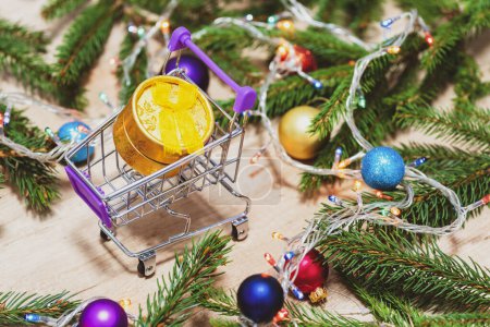 Einkaufswagen mit Weihnachtsgeschenk. Zweige eines Weihnachtsbaums. Warenkorb mit Geschenken. Konzept für Weihnachtseinkäufe.