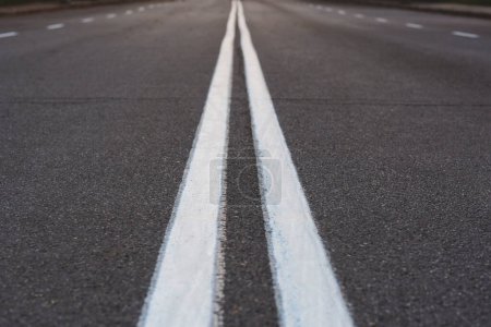 Photo for The asphalted road with two continuous white strips. The highway with a white marking. Concept long way, beginning something - Royalty Free Image