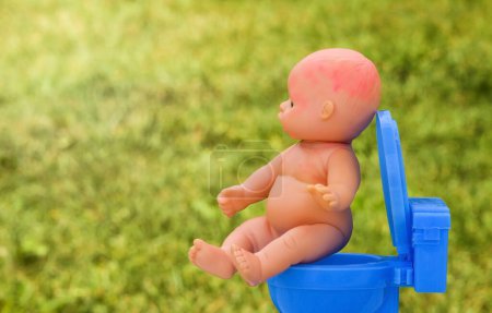 poupée de bébé assise sur un pot. enseigner à l'enfant à s'entraîner au pot. Concept pour l'enfant ne veut pas sur un pot. Concept de méconium chez l'enfant