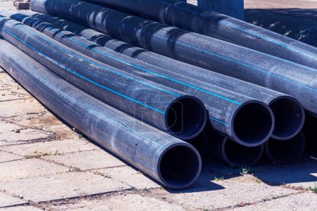 Plastic main black pipes. A heap of polyethylene pipes for a water supply system. Objects for laying of city communications and the sewerage. The concept of laying urban communications