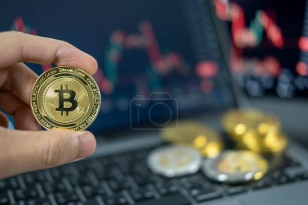 Photo for Hand holding a coin Cryptocurrency. Bitcoin on chart background. Virtual cryptocurrency concept. digital crypto currency for defi decentralized financial banking p2p exchange investment technology - Royalty Free Image