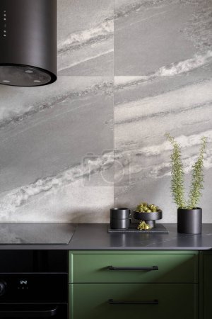 Foto de Cocina de moda con grandes azulejos grises, muebles verdes y encimera negra y electrodomésticos de cocina - Imagen libre de derechos