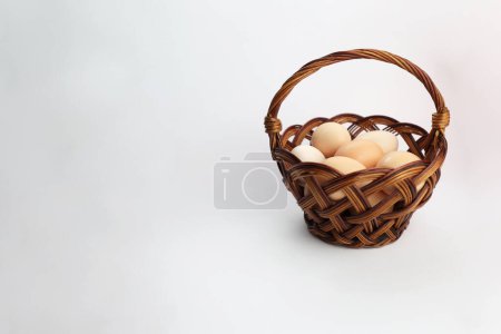 Huevos de Pascua. Huevos sobre fondo blanco. Huevos de pollo en una canasta. Una canasta sobre un fondo blanco para Pascua