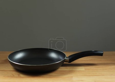 La poêle est noire sur la table. Une poêle, un ustensile de cuisine qui contient de l'huile pour la friture. Cuisiner le petit déjeuner à la maison.