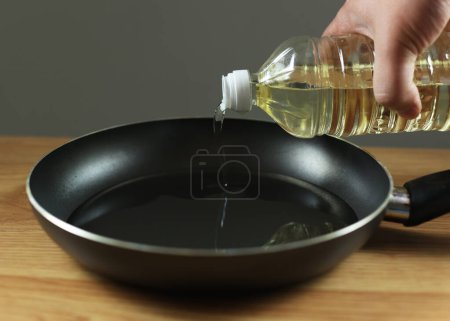 The pan is black on the table. A frying pan, a kitchen utensil into which oil is poured for frying. Cooking breakfast at home.