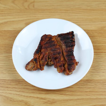 Cooking pork. Grilled meat, homemade barbecue. Juicy grilled steak. Tasty and appetizing pork. We prepare meat steaks at home. Pork on a white plate