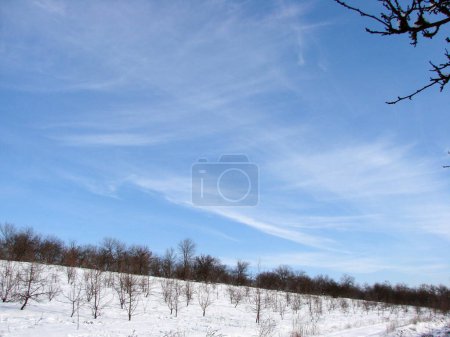 Ein faszinierendes natürliches Bild verschiedener Wolkenmuster in einem sonnigen blauen Himmel an einem frostigen Wintertag.