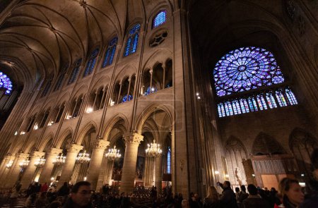 Téléchargez les photos : PARIS, FRANCE - 31 DÉCEMBRE 2011 : Cathédrale Notre Dame de Paris, intérieur, panorama des vitraux, arches pointues, colonnes et peintures sur les murs - en image libre de droit