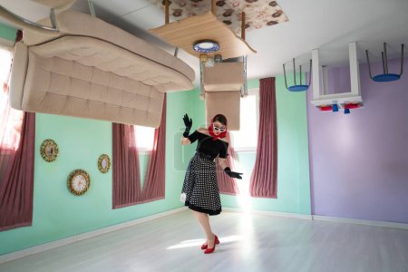 a girl retro style, surprised, in an upside-down house, as well as furniture placed on the up