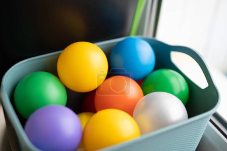 Téléchargez les photos : Jouets pour enfants boules en plastique coloré dans un panier - en image libre de droit
