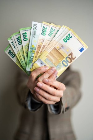 dame d'affaires tient des billets en euros dans ses mains