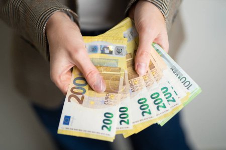 Geschäftsfrau hält Euro-Scheine in der Hand
