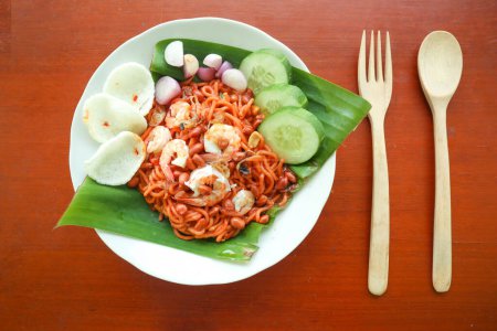 Mi Aceh, Mie Aceh oder Acehnese Nudeln ist ein würziges Gericht typisch für Aceh, bestehend aus dicken gelben Nudeln, Scheiben Rindfleisch, Hammelfleisch oder Garnelen, in Scheiben geschnittenen roten Zwiebeln, Gurken mit einer pikanten Curry-Sauce.