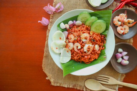 Mi Aceh, Mie Aceh oder Acehnese Nudeln ist ein würziges Gericht typisch für Aceh, bestehend aus dicken gelben Nudeln, Scheiben Rindfleisch, Hammelfleisch oder Garnelen, in Scheiben geschnittenen roten Zwiebeln, Gurken mit einer pikanten Curry-Sauce.