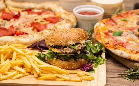 Téléchargez les photos : Pizza et hamburger sur fond bois - en image libre de droit