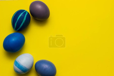 Foto de Variation of Blue Easter Eggs on yellow background - Imagen libre de derechos