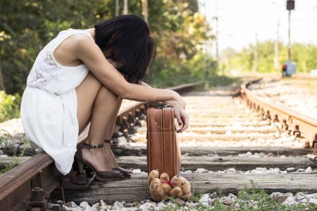 Téléchargez les photos : Sad girl on the railway. Throw teddy bear - en image libre de droit