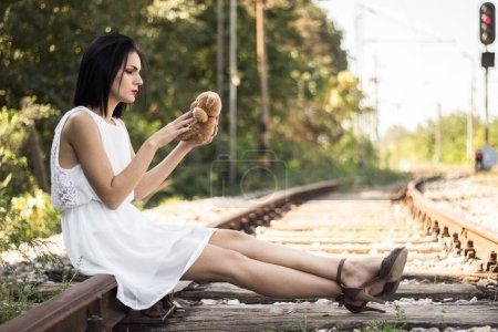 Téléchargez les photos : Sad girl on the railway. Throw teddy bear - en image libre de droit
