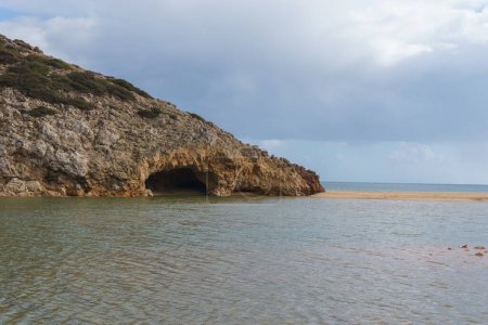 Cave at Praia das Furnas beach with sea water, Algarve, Portugal.