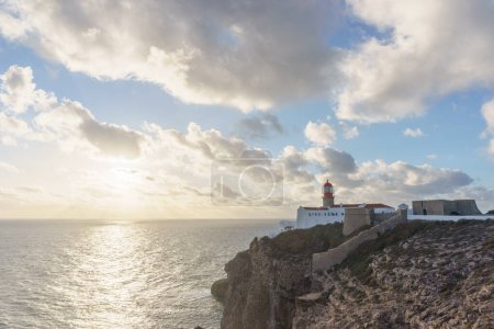 Sunset at lighthouse of Cabo de Sao Vicente with sunlight shining through clouds, Sagres, Algarve, Portugal