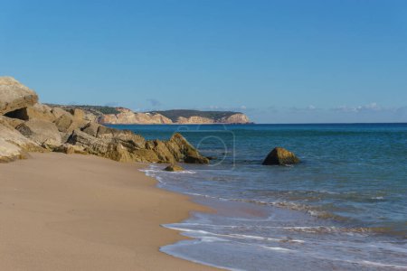 Praia da Andorinha beach on a sunny day with clear blue sky, Algarve, Portugal.