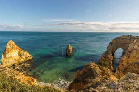 Golden cliffs at the coastline of the Atlantic Ocean with famous two arch rock formation Elephant Rock near the Cave of Benagil, Algarve, Portugal
