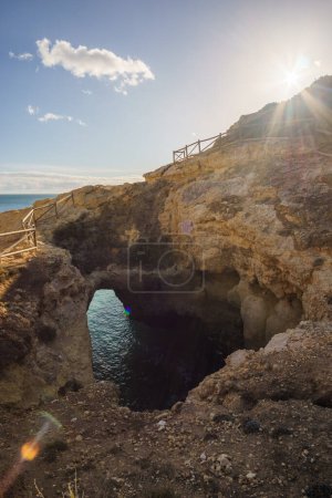 Eine Höhle von oben mit Blick auf die Atlantikküste in der Nähe von Lagoa, Algarve, Portugal.